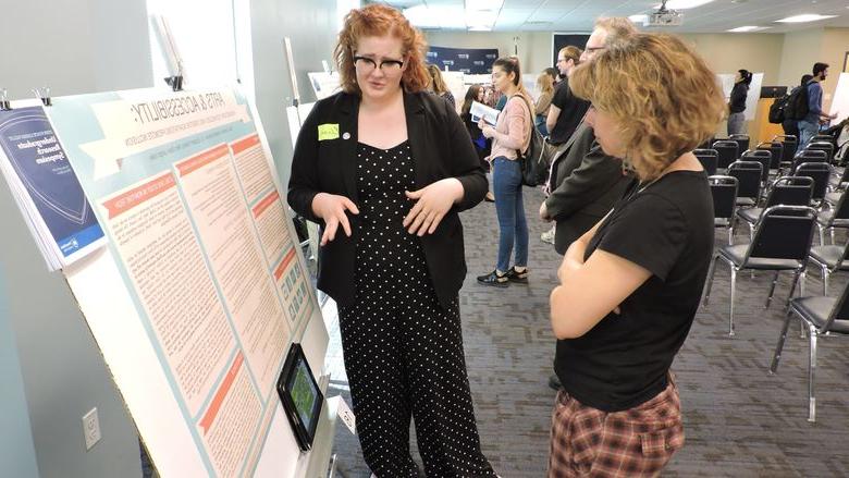 two women reviewing a research poster 
